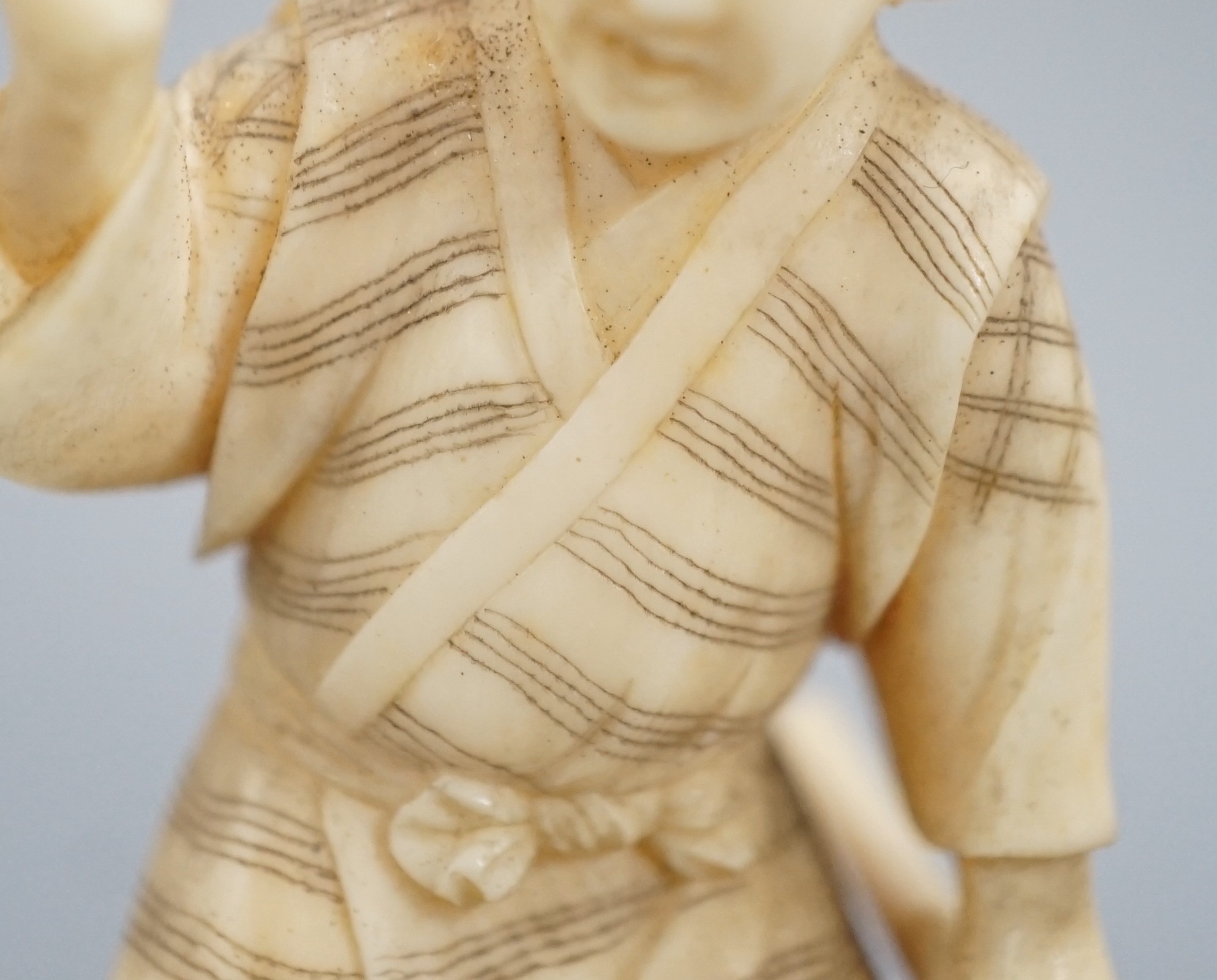 A Japanese ivory okimono of a monkey trainer, signed, Meiji period, 7.7 cm